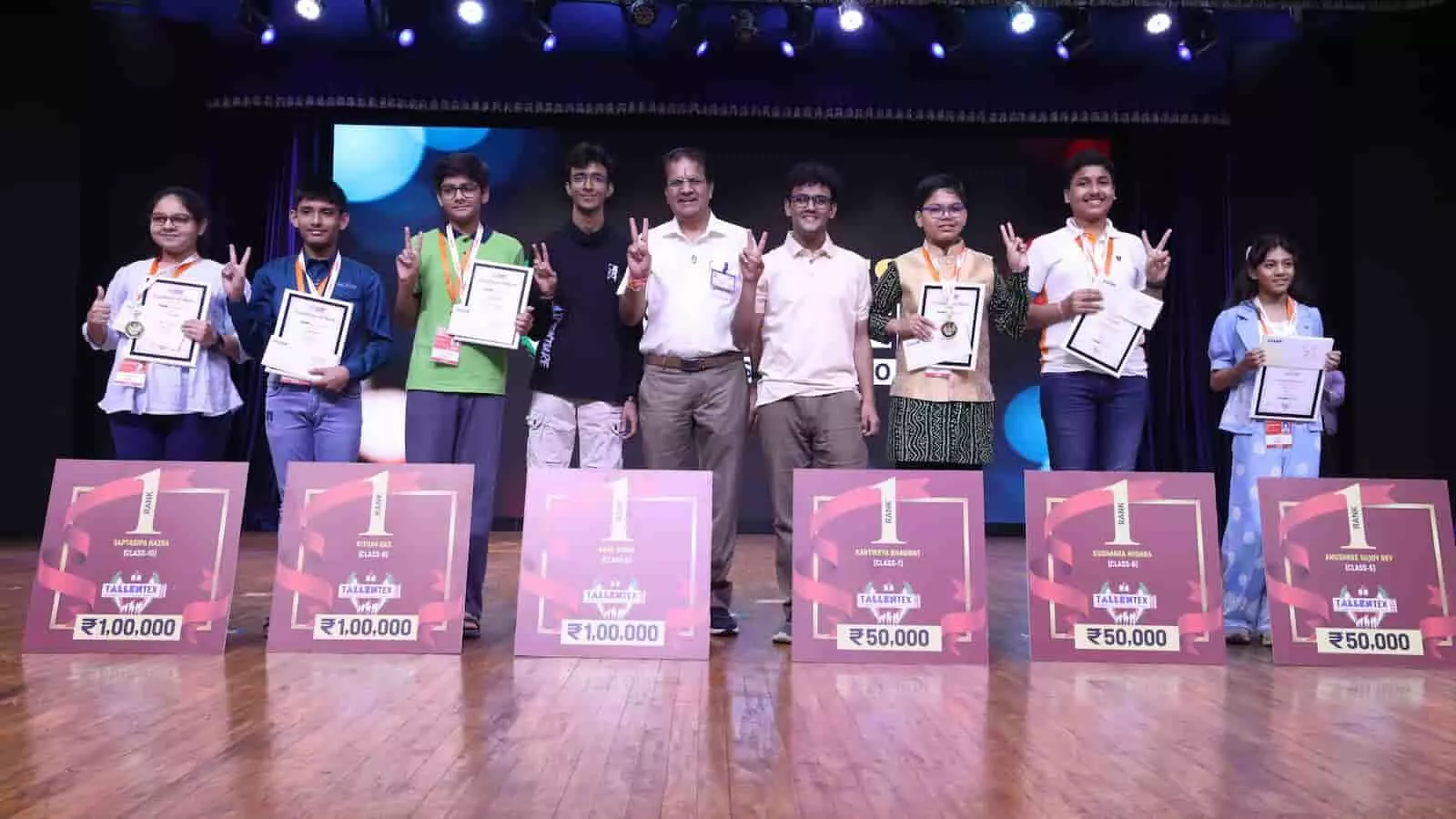 एलन टैलेंटेक्स पुरस्कार समारोह में मंच पर खड़े होकर पुरस्कार लेते छात्र और शिक्षक।