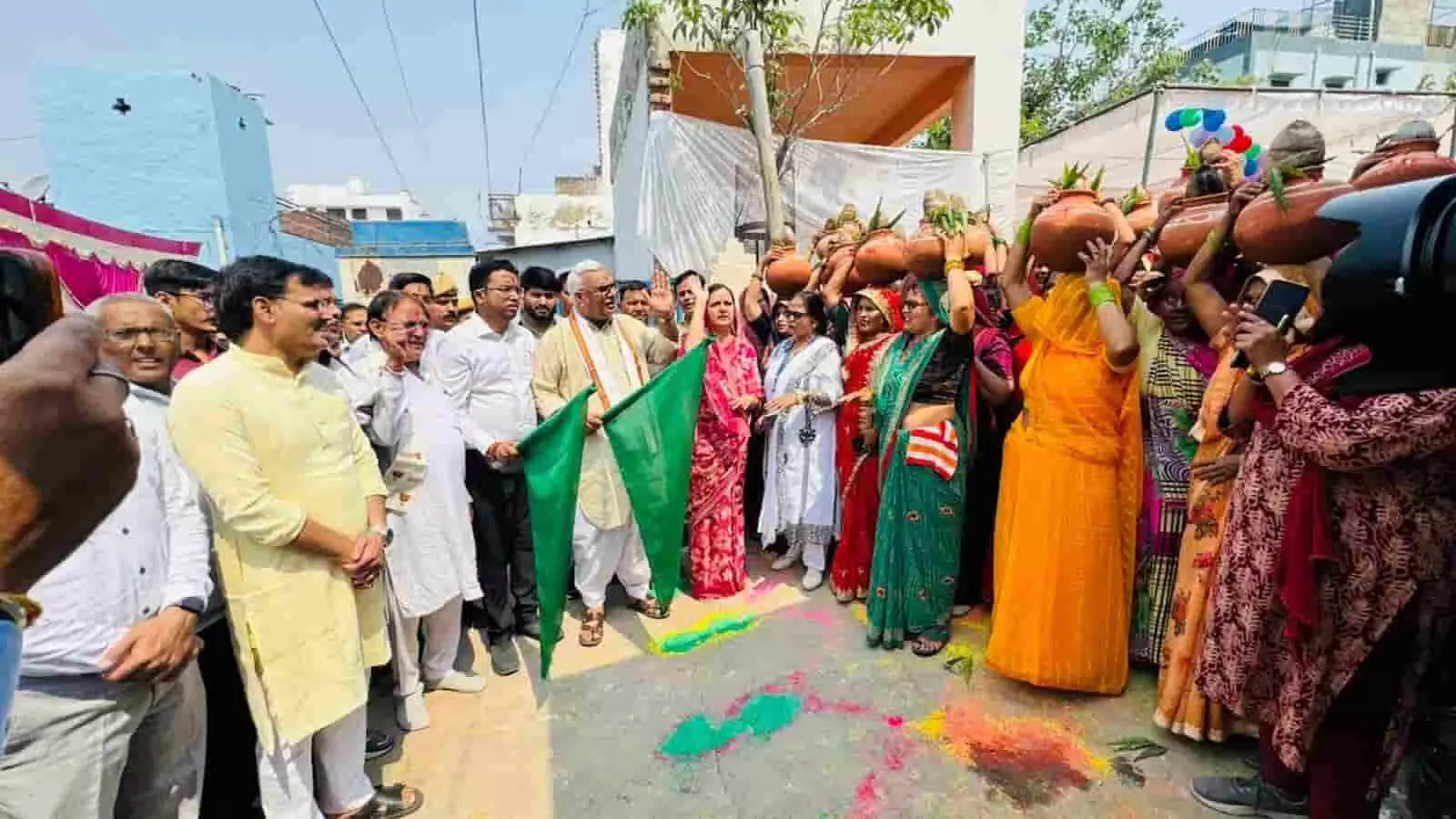 डीग के मंदिर परिसर में हरी झंडी दिखाते जवाहर सिंह बेढ़म और कलश लिए महिलाएं। डीग के मंदिर परिसर में हरी झंडी दिखाते जवाहर सिंह बेढ़म और कलश लिए महिलाएं।