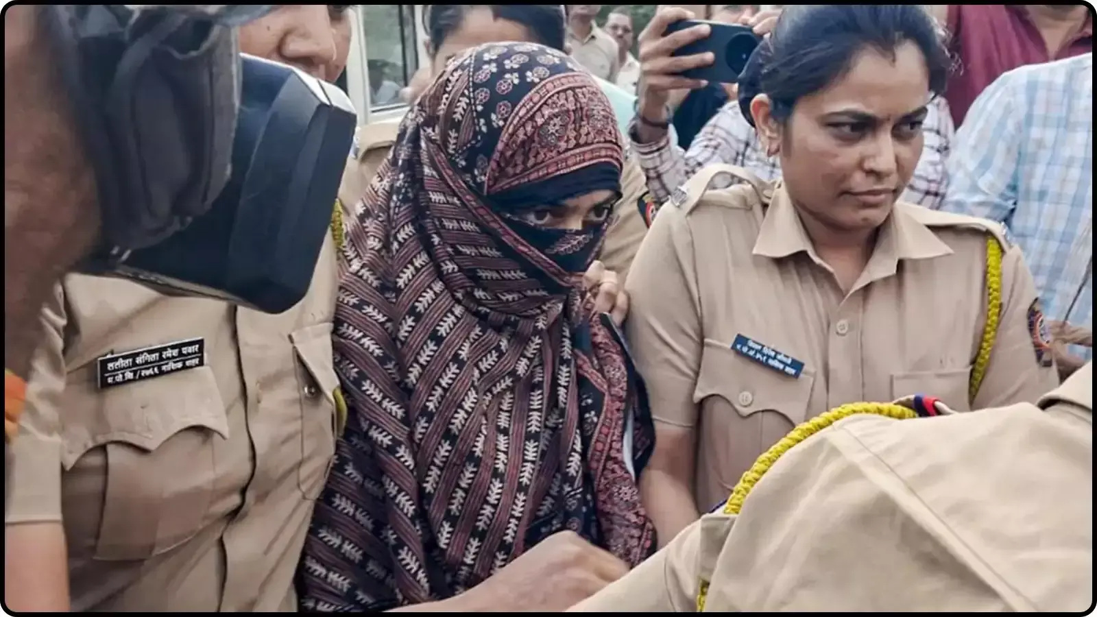 पुलिस कर्मियों के बीच सिर और चेहरे को स्कार्फ से ढके हुए एक महिला। पुलिस कर्मियों के बीच सिर और चेहरे को स्कार्फ से ढके हुए एक महिला।
