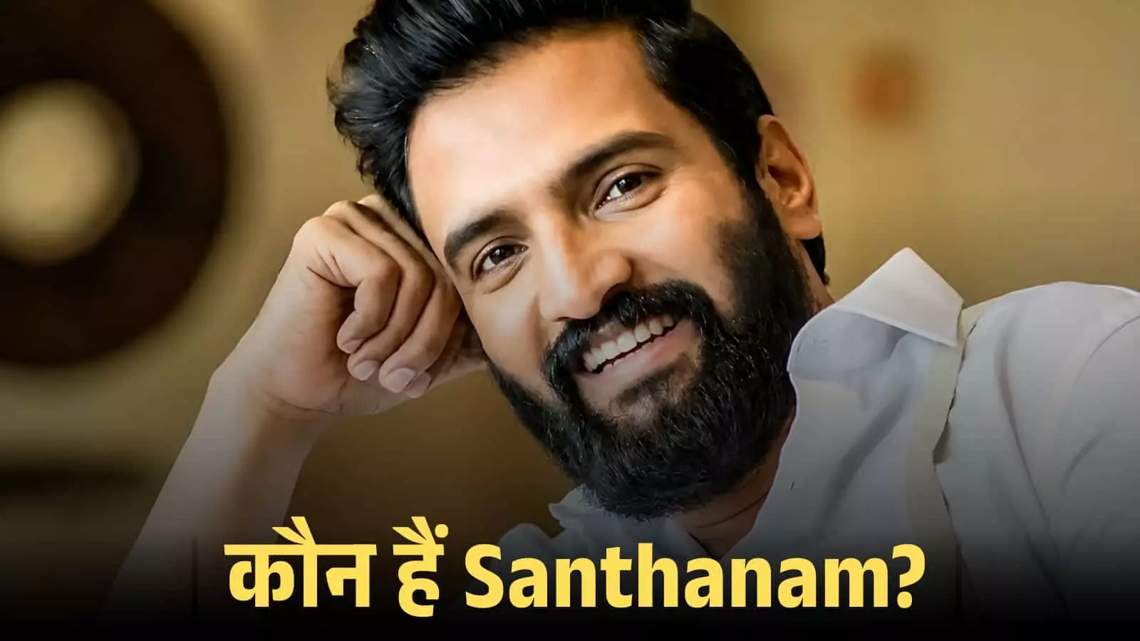 मुस्कुराते हुए तमिल अभिनेता संथानम सफेद शर्ट में एक इनडोर फोटोशूट के दौरान पोज़ देते हुए। मुस्कुराते हुए तमिल अभिनेता संथानम सफेद शर्ट में एक इनडोर फोटोशूट के दौरान पोज़ देते हुए।