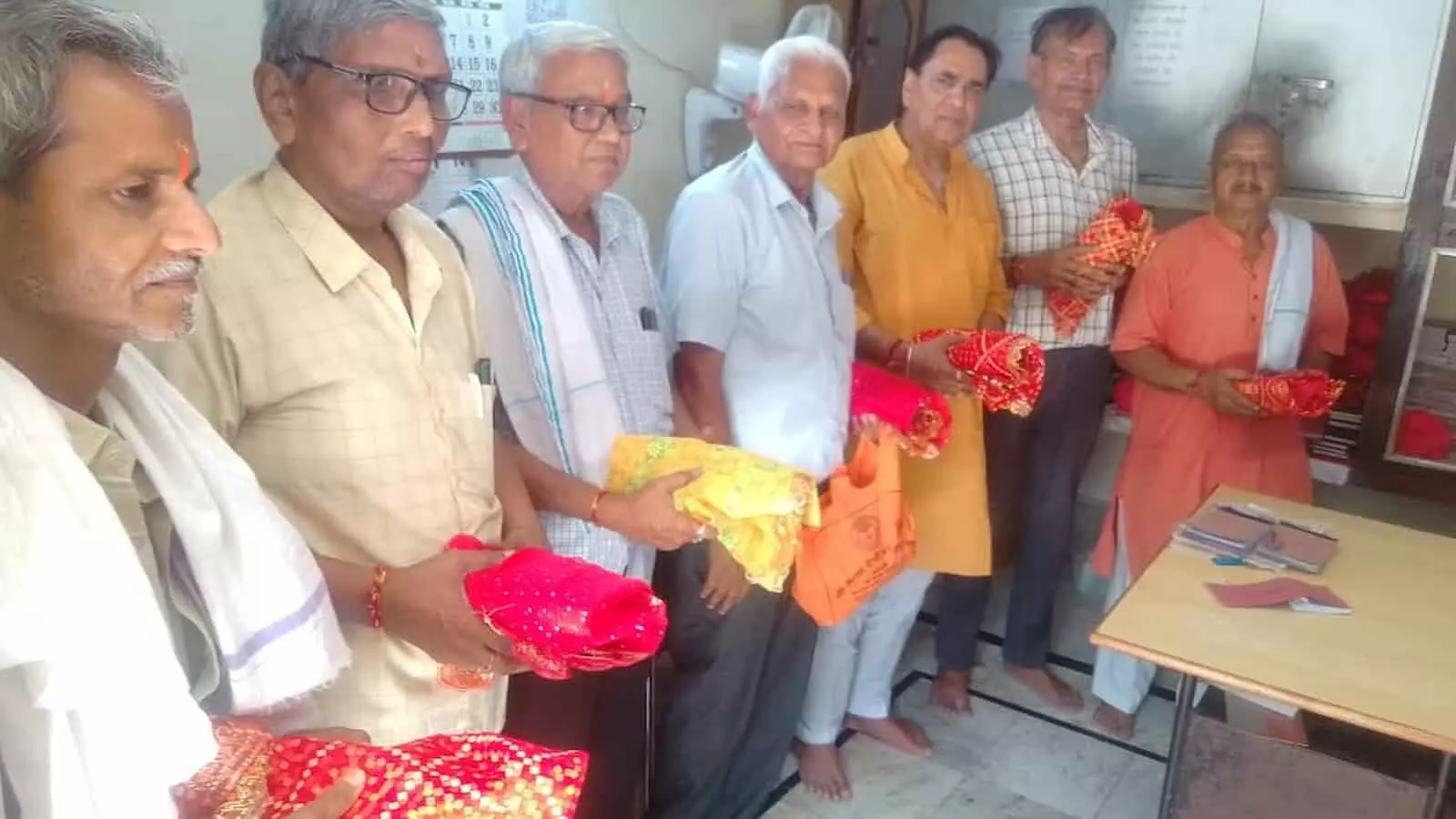 कैला देवी सेवा संस्थान के पदाधिकारी मंदिर परिसर में आयोजन की सामग्री और लाल चुनरी के साथ खड़े हैं। कैला देवी सेवा संस्थान के पदाधिकारी मंदिर परिसर में आयोजन की सामग्री और लाल चुनरी के साथ खड़े हैं।