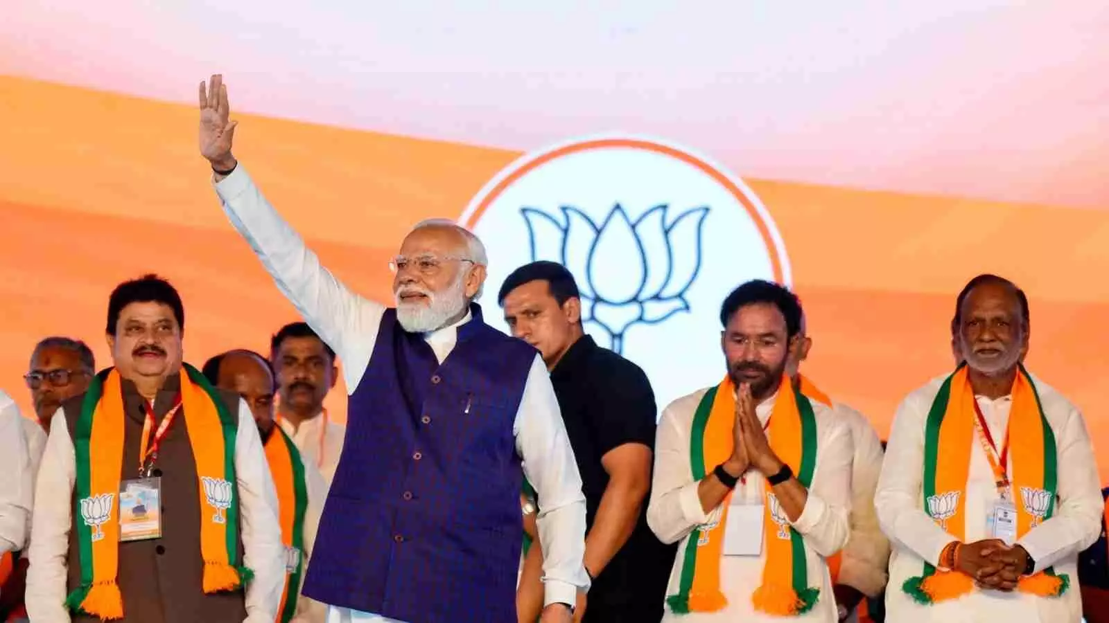 हैदराबाद में जनसभा के दौरान मंच पर हाथ उठाकर अभिवादन करते प्रधानमंत्री नरेंद्र मोदी और अन्य भाजपा नेता।