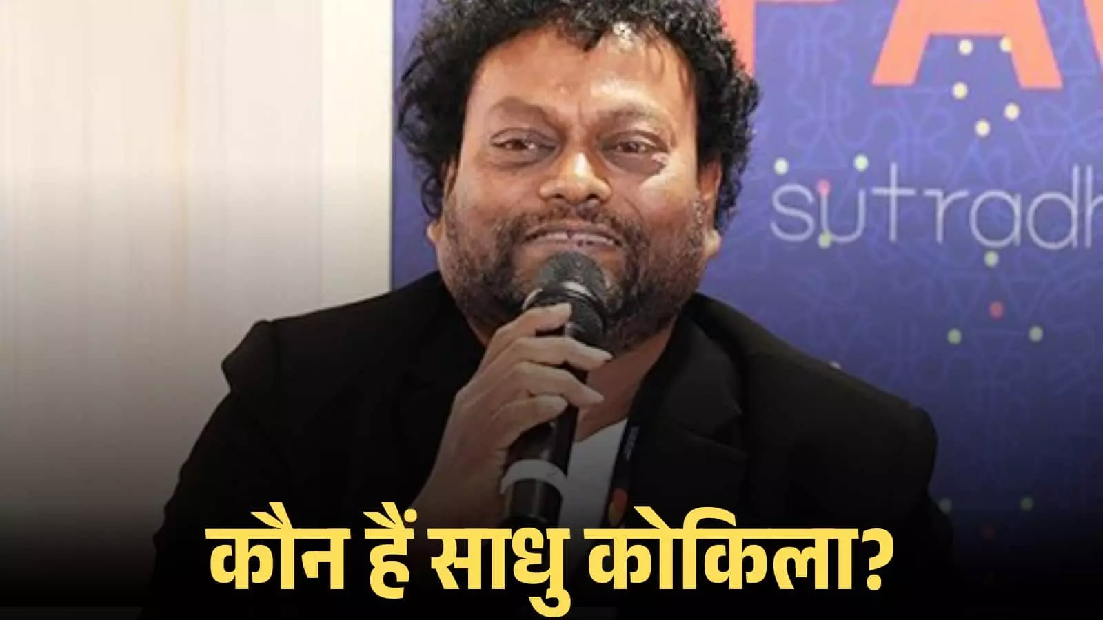 हाथ में माइक्रोफोन लिए मंच पर बात करते अभिनेता साधु कोकिला की तस्वीर। हाथ में माइक्रोफोन लिए मंच पर बात करते अभिनेता साधु कोकिला की तस्वीर।