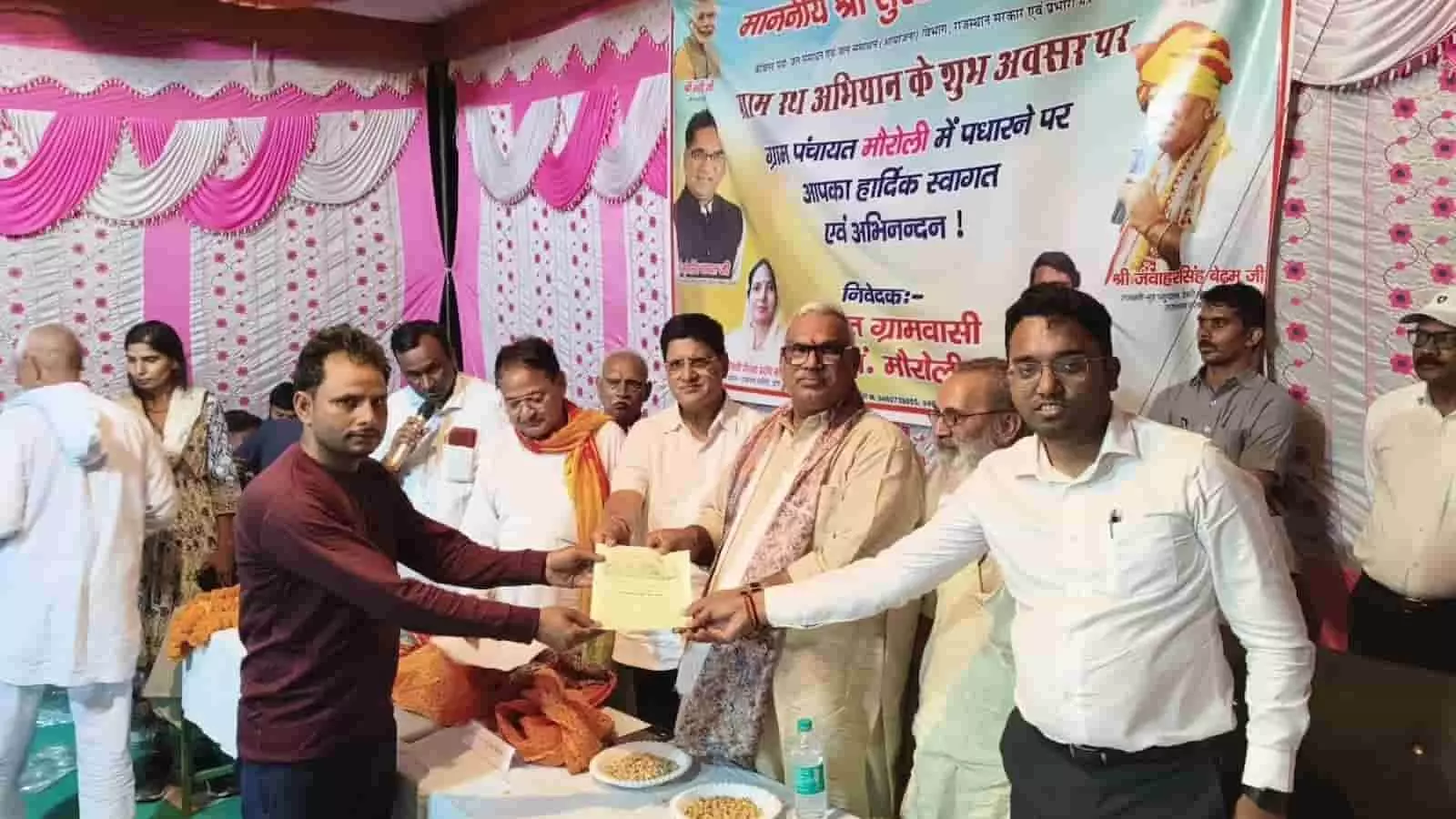 मौरोली ग्राम पंचायत में गृह राज्य मंत्री जवाहर सिंह बेढ़म ग्रामीण को आवासीय पट्टे का दस्तावेज सौंपते हुए। मौरोली ग्राम पंचायत में गृह राज्य मंत्री जवाहर सिंह बेढ़म ग्रामीण को आवासीय पट्टे का दस्तावेज सौंपते हुए।