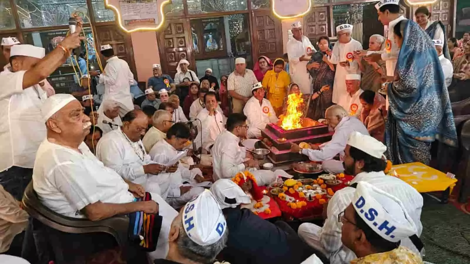 श्री झूलेलाल मंदिर जयपुर में हवन कुंड के चारों ओर बैठकर आहुति देते श्रद्धालु और सेवादार।