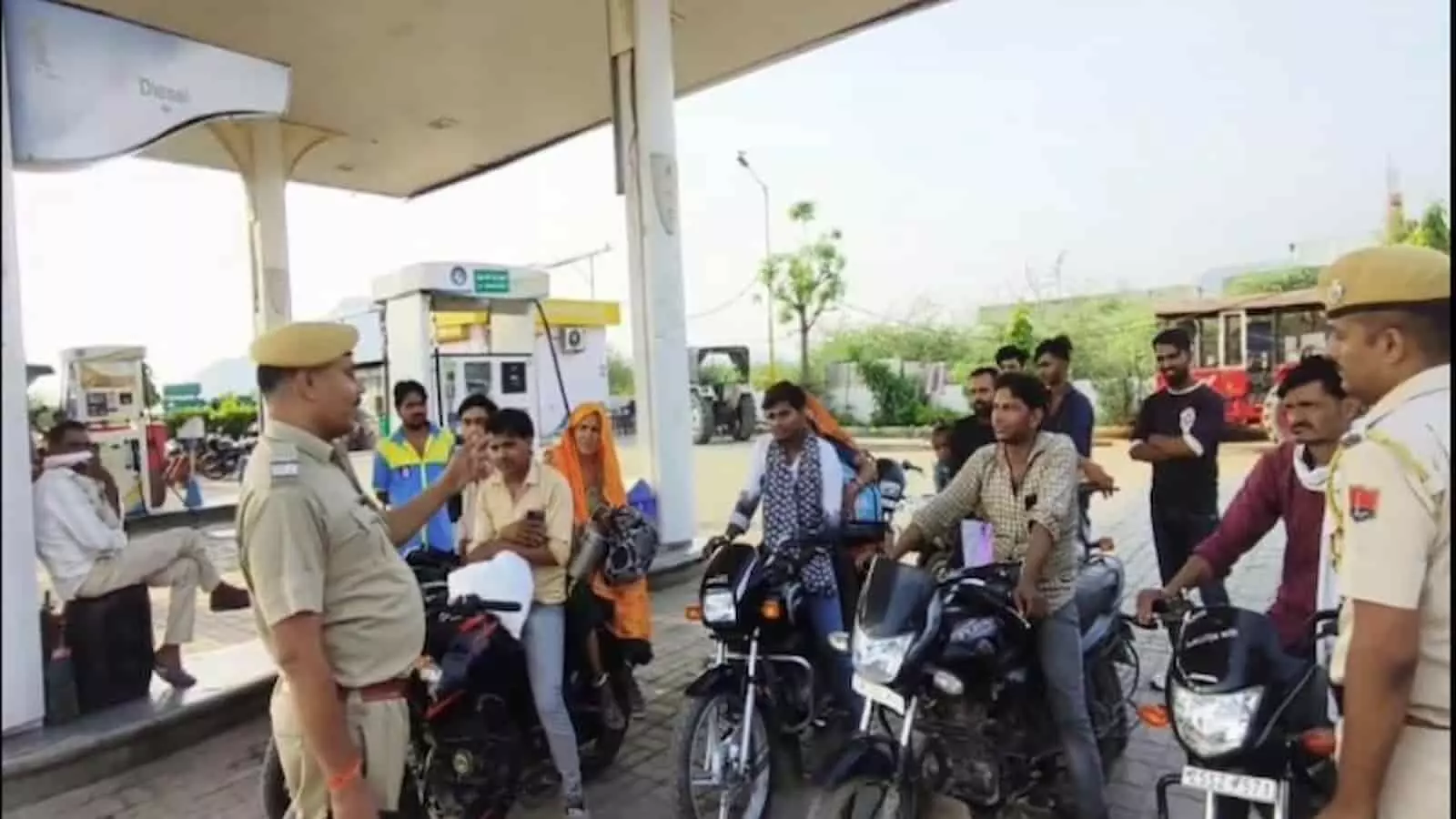 पेट्रोल पंप पर पुलिस अधिकारी मोटरसाइकिल चालकों को सड़क सुरक्षा और यातायात नियमों के बारे में जागरूक करते हुए। पेट्रोल पंप पर पुलिस अधिकारी मोटरसाइकिल चालकों को सड़क सुरक्षा और यातायात नियमों के बारे में जागरूक करते हुए।
