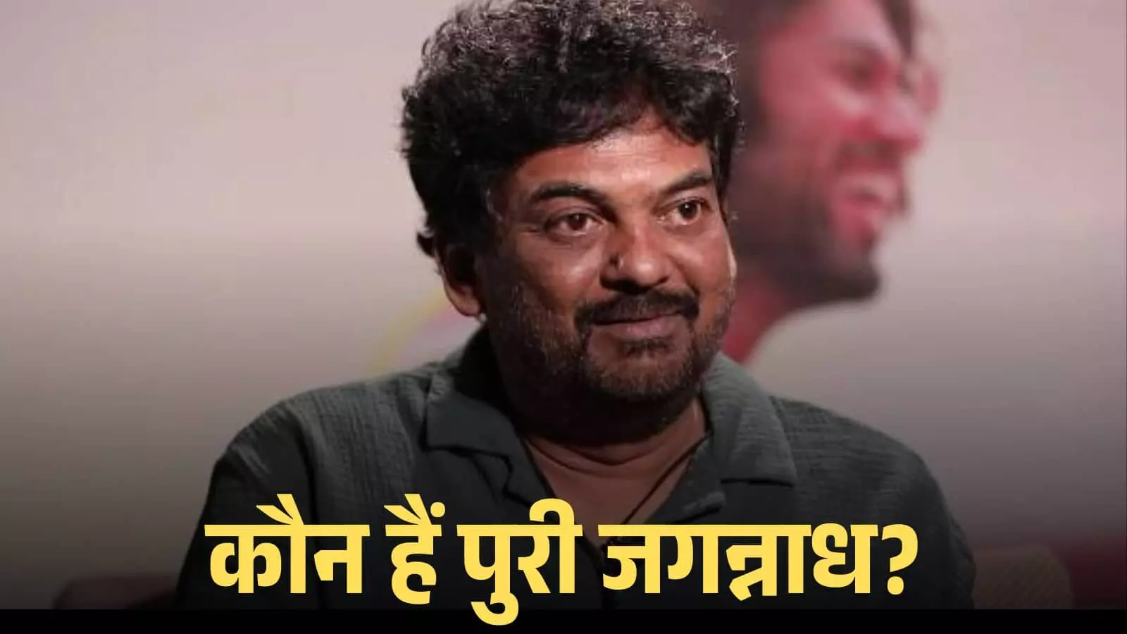 कैमरे की ओर देखते हुए मुस्कुराते फिल्म निर्देशक पुरी जगन्नाथ एक स्टूडियो में बैठे हुए। कैमरे की ओर देखते हुए मुस्कुराते फिल्म निर्देशक पुरी जगन्नाथ एक स्टूडियो में बैठे हुए।