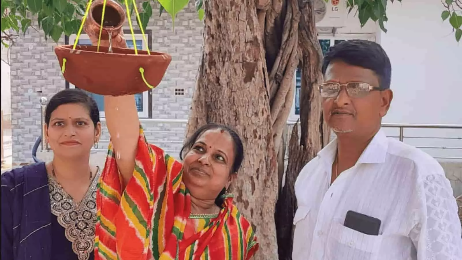 सवाई माधोपुर में पेड़ पर टंगे मिट्टी के परिंडे में पानी भरती महिलाएं और खड़े राजेश गोयल। सवाई माधोपुर में पेड़ पर टंगे मिट्टी के परिंडे में पानी भरती महिलाएं और खड़े राजेश गोयल।