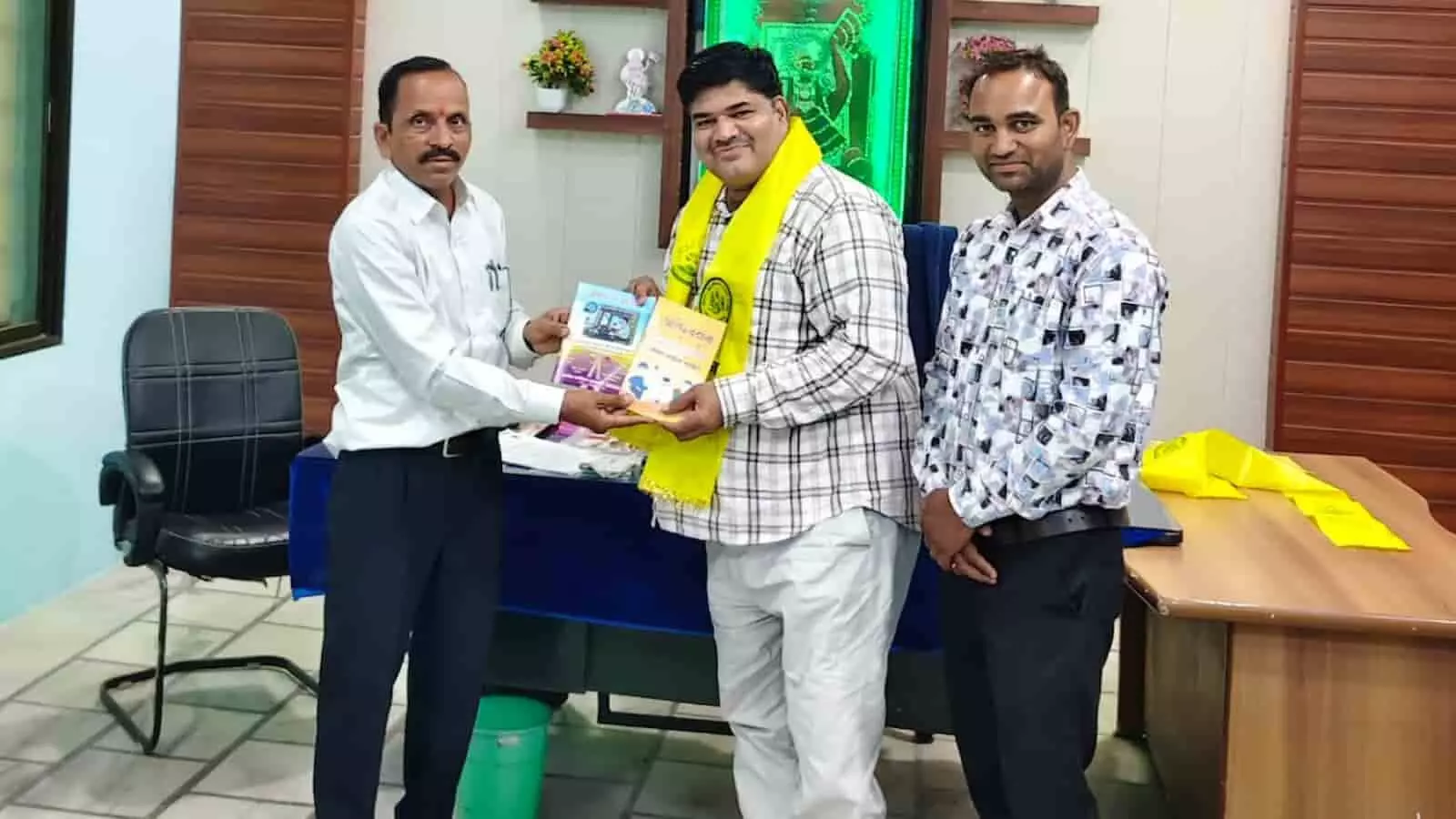 कार्यालय में नारायण सिंह राव मुकेश वैष्णव को पुस्तक भेंट कर सम्मानित करते हुए दिख रहे हैं। कार्यालय में नारायण सिंह राव मुकेश वैष्णव को पुस्तक भेंट कर सम्मानित करते हुए दिख रहे हैं।