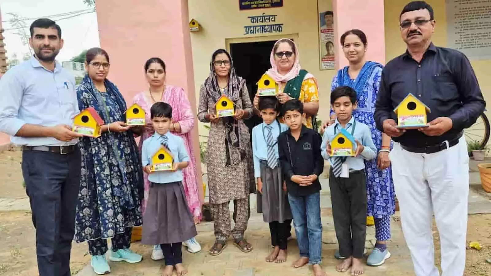 झुंझुनू के दुलचास स्कूल में पक्षी घर पकड़े हुए शिक्षक और छात्र पर्यावरण संरक्षण अभियान के दौरान।