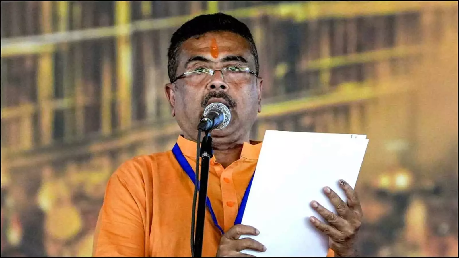 भगवा कुर्ता पहने और हाथ में कागज लिए सुवेंदु अधिकारी पश्चिम बंगाल में प्रशासनिक संबोधन के दौरान। भगवा कुर्ता पहने और हाथ में कागज लिए सुवेंदु अधिकारी पश्चिम बंगाल में प्रशासनिक संबोधन के दौरान।