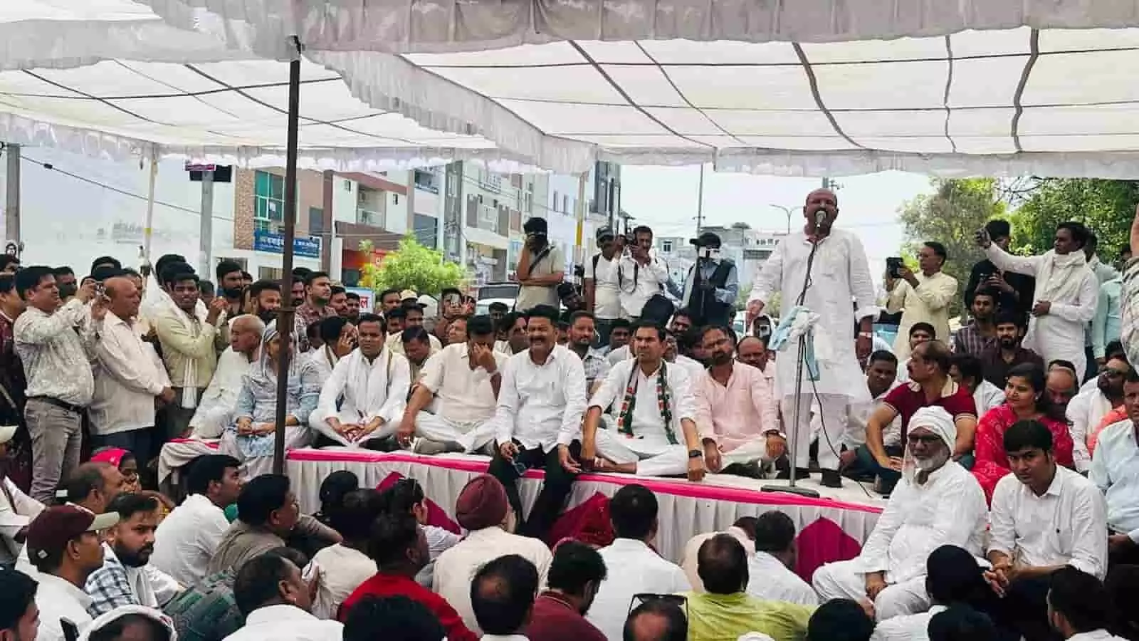कोटा में न्यू मेडिकल कॉलेज के बाहर मंच पर भाषण देते प्रहलाद गुंजल और बैठे हुए कांग्रेस कार्यकर्ता। कोटा में न्यू मेडिकल कॉलेज के बाहर मंच पर भाषण देते प्रहलाद गुंजल और बैठे हुए कांग्रेस कार्यकर्ता।