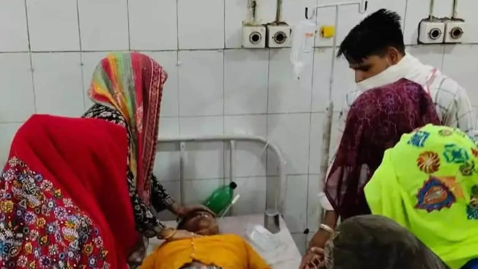 बयाना अस्पताल के बिस्तर पर उपचारधीन करंट से झुलसी महिला और उसके पास खड़े ग्रामीण। बयाना अस्पताल के बिस्तर पर उपचारधीन करंट से झुलसी महिला और उसके पास खड़े ग्रामीण।