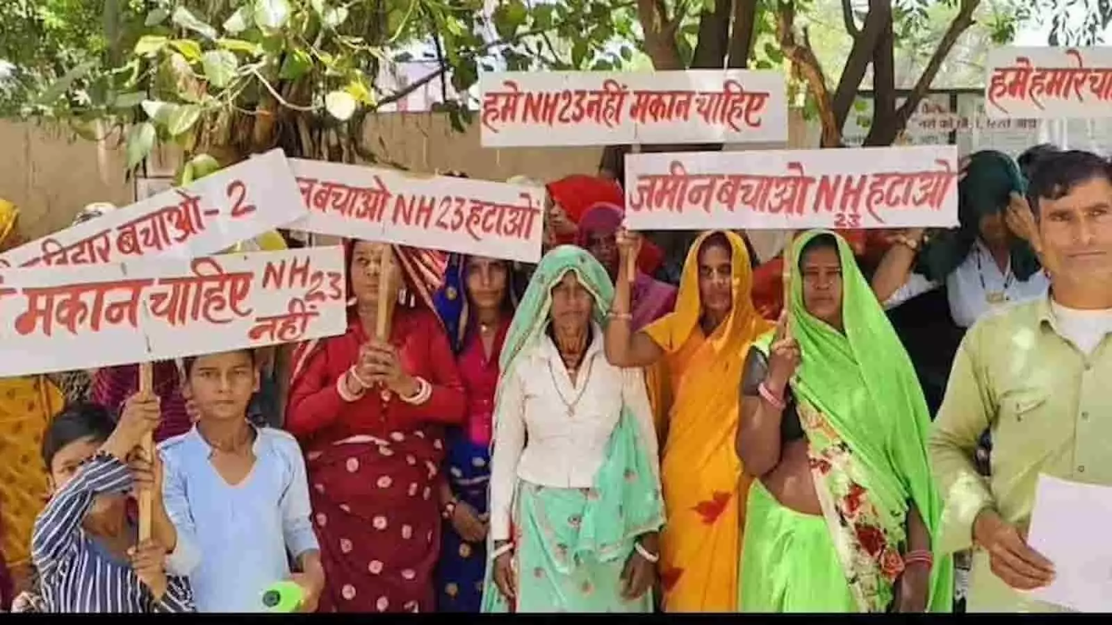 करौली में एनएच-23 बाईपास सर्वे के खिलाफ तख्तियां पकड़े प्रदर्शन करते लोग।