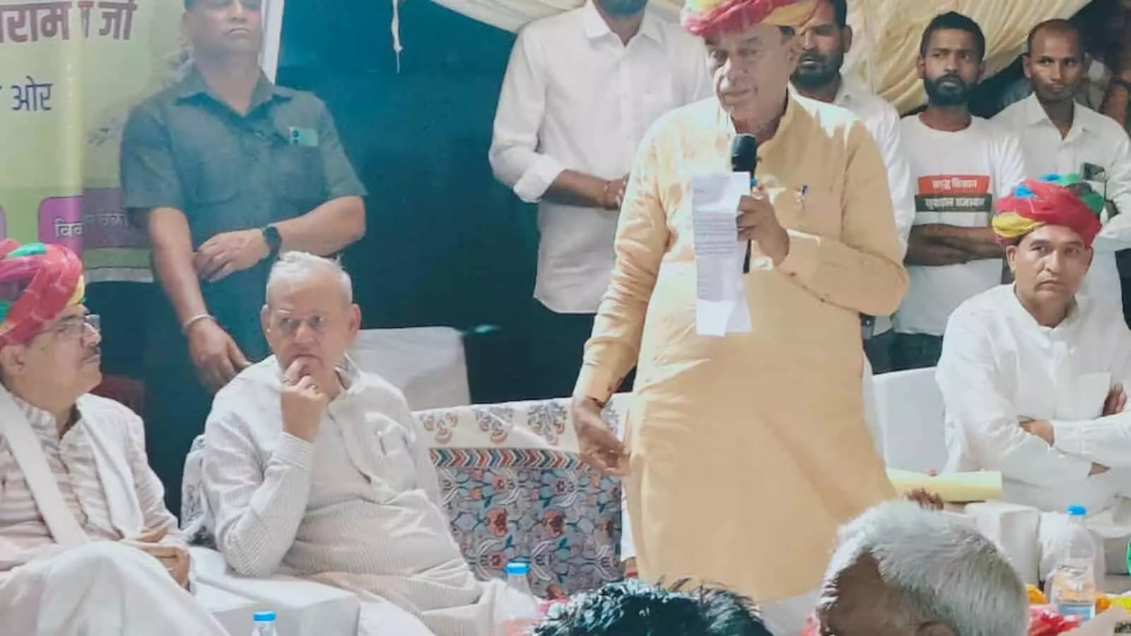 संध्या चौपाल के दौरान माइक थामे भाषण देते मंत्री जोगाराम पटेल शाहपुरा जनसुनवाई के मंच पर।
