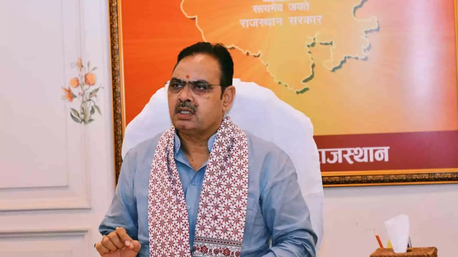कार्यालय में बैठे मुख्यमंत्री भजनलाल शर्मा राजस्थान सरकार के प्रतीक चिन्ह के सामने चर्चा कर रहे हैं।