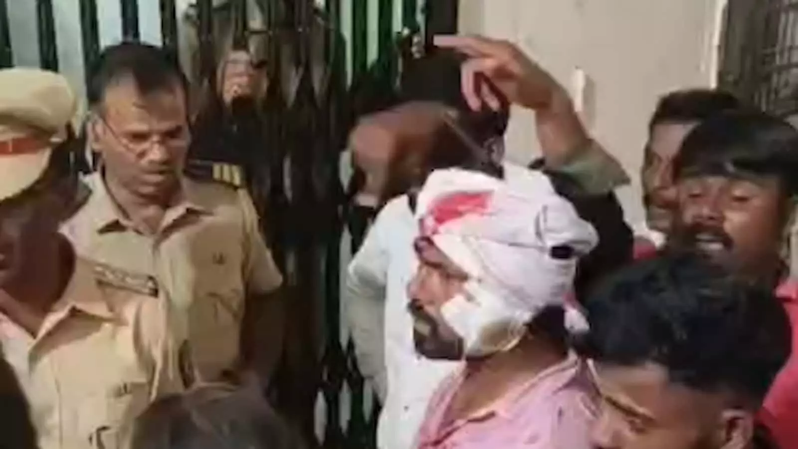 अस्पताल परिसर में घायल व्यक्ति और पुलिसकर्मी हिंसक झड़प के बाद स्थिति संभालते हुए। अस्पताल परिसर में घायल व्यक्ति और पुलिसकर्मी हिंसक झड़प के बाद स्थिति संभालते हुए।