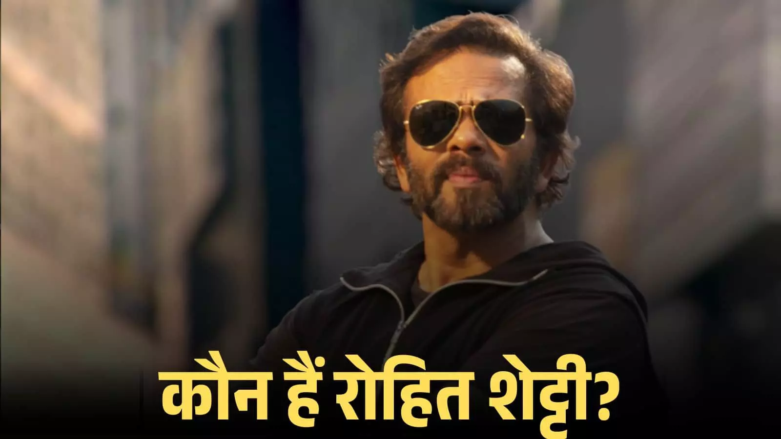 चश्मा पहने हुए निर्देशक रोहित शेट्टी एक फिल्म सेट के बैकग्राउंड में गंभीर मुद्रा में खड़े हैं। चश्मा पहने हुए निर्देशक रोहित शेट्टी एक फिल्म सेट के बैकग्राउंड में गंभीर मुद्रा में खड़े हैं।