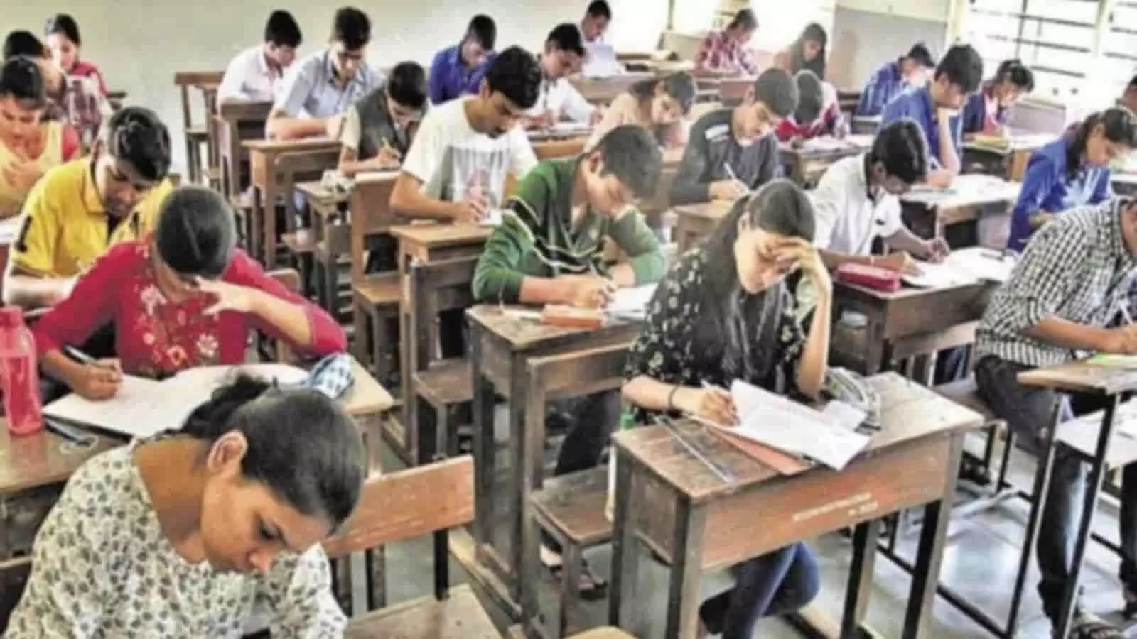 परीक्षा केंद्र में डेस्क पर बैठकर नीट परीक्षा का पेपर देते हुए अनेक छात्र और छात्राएं। परीक्षा केंद्र में डेस्क पर बैठकर नीट परीक्षा का पेपर देते हुए अनेक छात्र और छात्राएं।