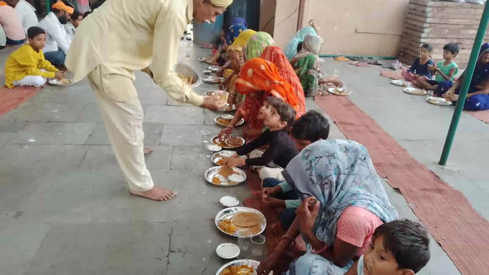 भुसावर की धर्मशाला में पंगत में बैठकर प्रसाद पाते हुए पुरुष महिलाएं और बच्चे। भुसावर की धर्मशाला में पंगत में बैठकर प्रसाद पाते हुए पुरुष महिलाएं और बच्चे।