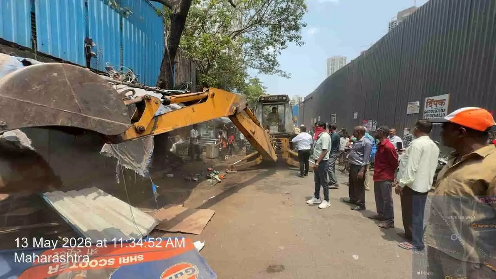 मुंबई में बीएमसी कर्मचारी जेसीबी मशीन से सड़क किनारे बने अवैध अतिक्रमण हटा रहे हैं। मुंबई में बीएमसी कर्मचारी जेसीबी मशीन से सड़क किनारे बने अवैध अतिक्रमण हटा रहे हैं।