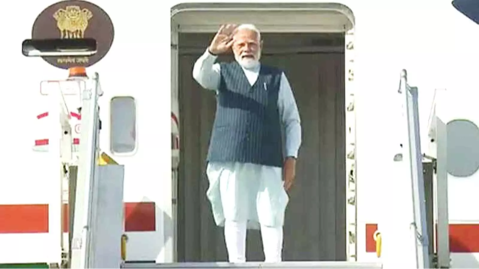 विमान के दरवाजे पर खड़े प्रधानमंत्री नरेंद्र मोदी हाथ हिलाकर लोगों का अभिवादन कर रहे हैं। विमान के दरवाजे पर खड़े प्रधानमंत्री नरेंद्र मोदी हाथ हिलाकर लोगों का अभिवादन कर रहे हैं।