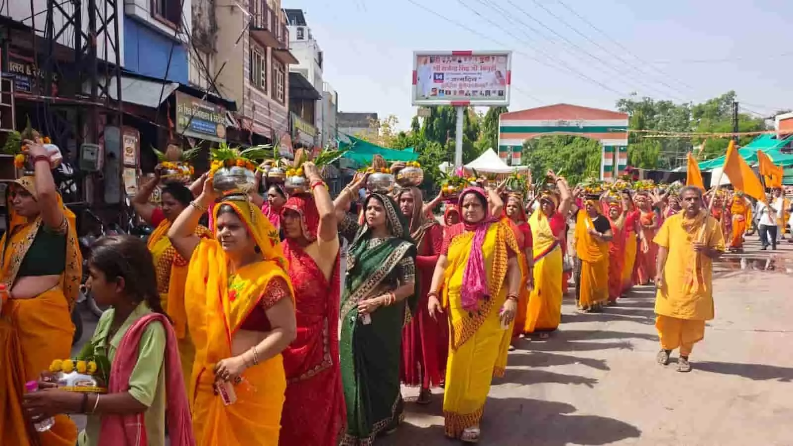 नीलकंठ महादेव मंदिर के पास पीली साड़ी पहने कलश यात्रा निकालती महिलाएं और धार्मिक ध्वज। नीलकंठ महादेव मंदिर के पास पीली साड़ी पहने कलश यात्रा निकालती महिलाएं और धार्मिक ध्वज।