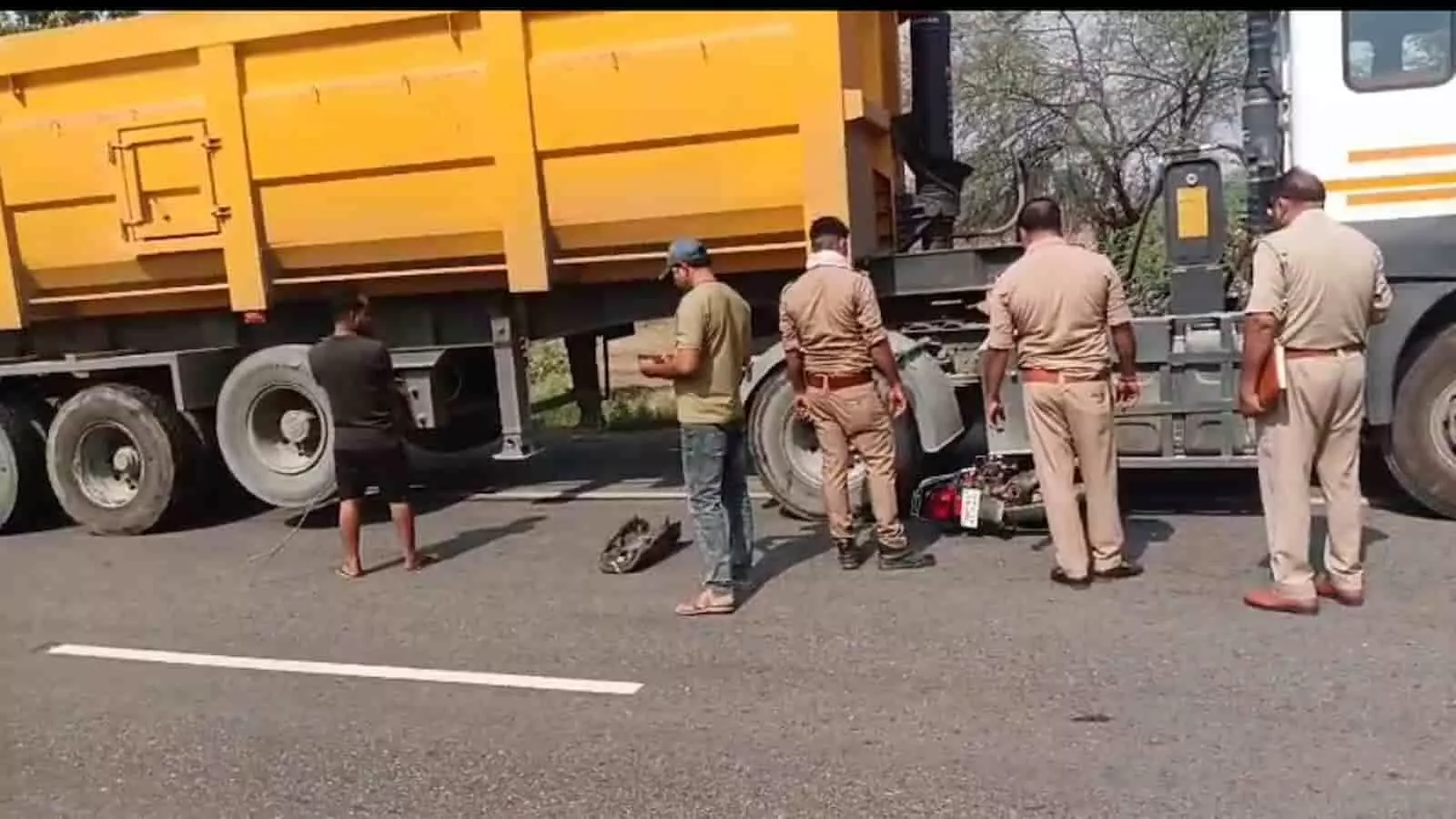 चिरगांव में सड़क पर खड़े ट्रक और क्षतिग्रस्त बाइक के पास खड़े पुलिसकर्मी और स्थानीय लोग। चिरगांव में सड़क पर खड़े ट्रक और क्षतिग्रस्त बाइक के पास खड़े पुलिसकर्मी और स्थानीय लोग।