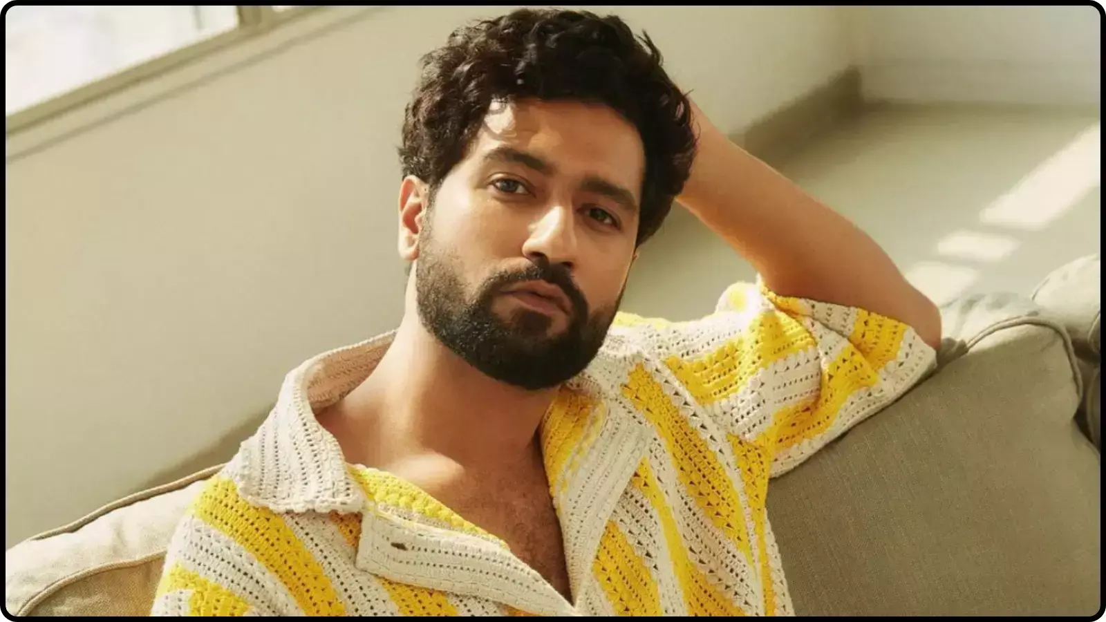 सोफे पर आराम करते हुए अभिनेता विक्की कौशल पीले और सफेद रंग की शर्ट में दिख रहे हैं।