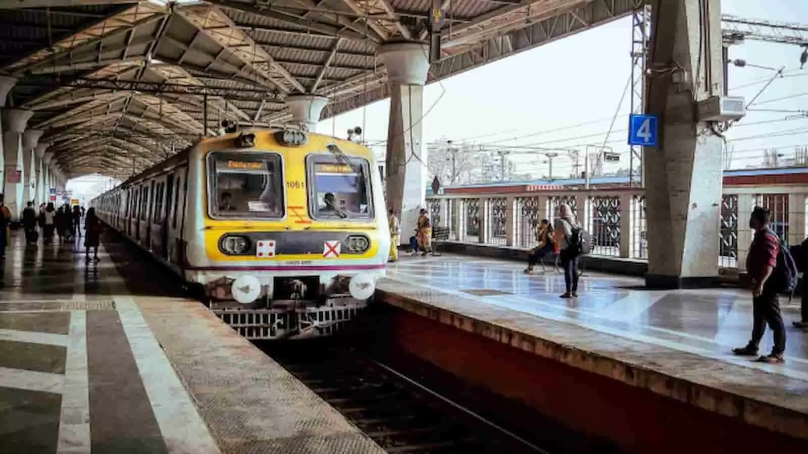 रेलवे स्टेशन के प्लेटफॉर्म पर आती हुई मुंबई लोकल ट्रेन और प्रतीक्षा करते यात्री। रेलवे स्टेशन के प्लेटफॉर्म पर आती हुई मुंबई लोकल ट्रेन और प्रतीक्षा करते यात्री।