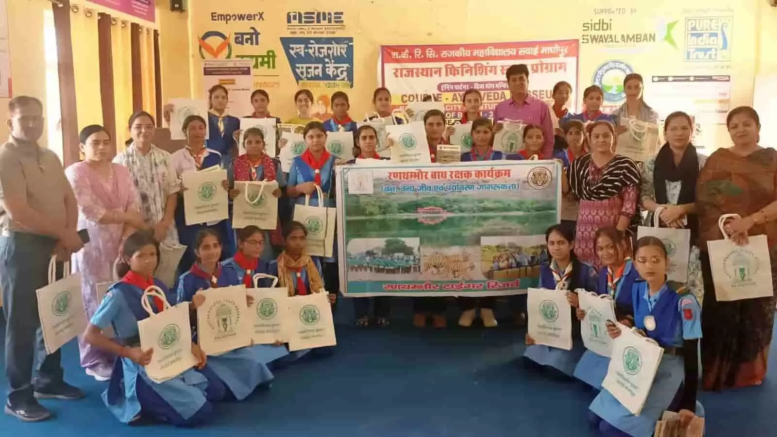 सवाई माधोपुर में रणथंभौर बाघ रक्षक कार्यक्रम के दौरान जूट बैग लेकर खड़ी छात्राएं और वन विभाग के अधिकारी।