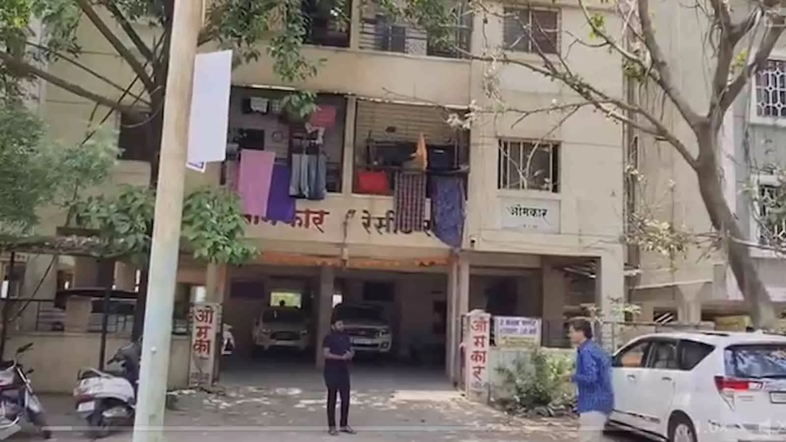 लातूर में नीट पेपर लीक जांच के दौरान कोचिंग संचालक के घर के बाहर खड़े लोग और वाहन।
