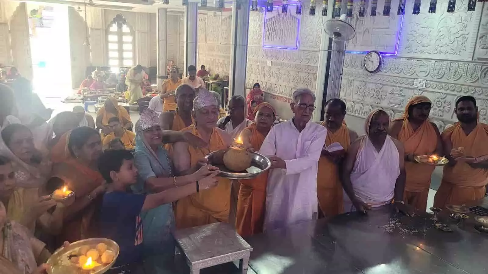 विज्ञान नगर दिगंबर जैन मंदिर में भगवान शांतिनाथ निर्वाण महोत्सव पर लाडू चढ़ाते श्रद्धालु और आयोजन समिति।