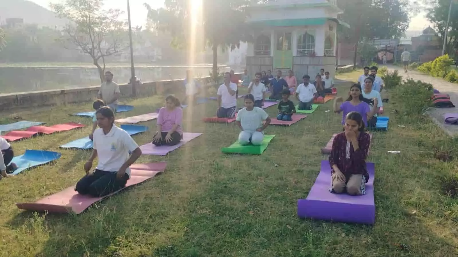 सेरिंग तालाब के किनारे योगासन करते हुए नागरिक और विद्यार्थी सलूंबर योग अभियान के दौरान।