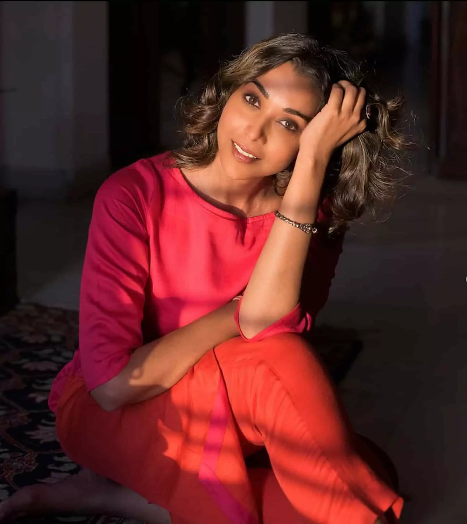 लाल और गुलाबी रंग की पोशाक में बैठी हुई अभिनेत्री अनुप्रिया गोयनका इंडोर बैकग्राउंड में पोज़ देते हुए। लाल और गुलाबी रंग की पोशाक में बैठी हुई अभिनेत्री अनुप्रिया गोयनका इंडोर बैकग्राउंड में पोज़ देते हुए।