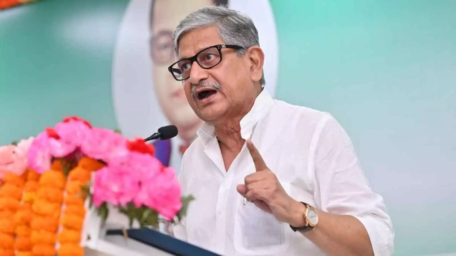 मंच पर भाषण देते हुए चश्मा पहने केंद्रीय मंत्री ललन सिंह जो उंगली दिखाकर अपनी बात रख रहे हैं।