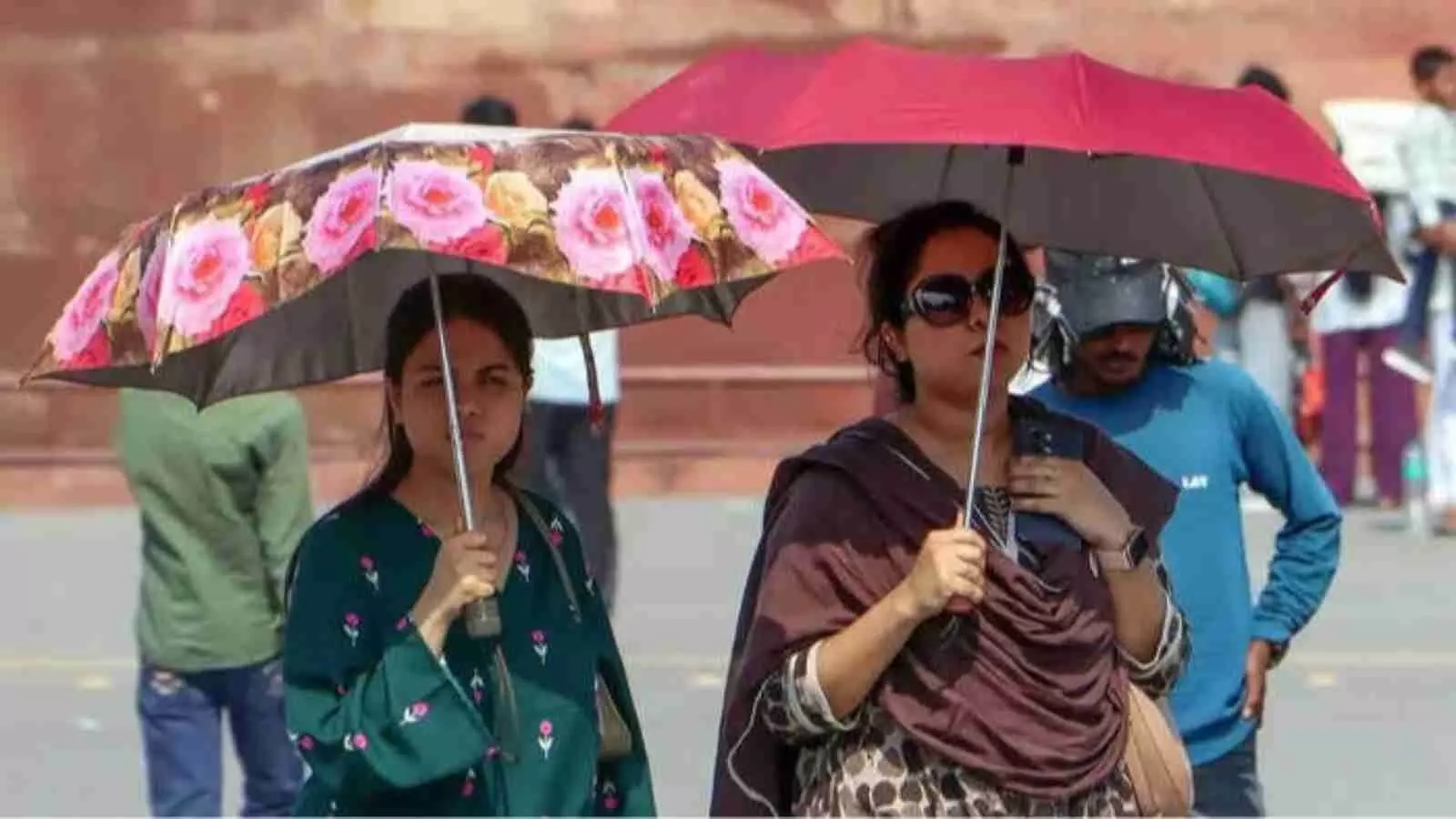 धूप से बचने के लिए छाता लगाए दो महिलाएं दिल्ली की सड़क पर भीषण गर्मी के बीच चल रही हैं। धूप से बचने के लिए छाता लगाए दो महिलाएं दिल्ली की सड़क पर भीषण गर्मी के बीच चल रही हैं।