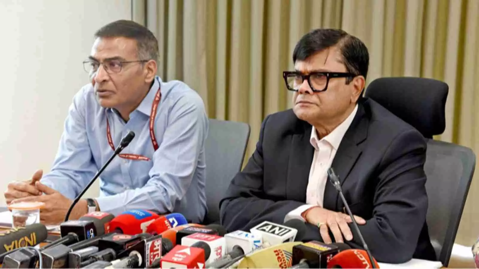 एक प्रेस कॉन्फ्रेंस के दौरान माइक के सामने बैठे दो प्रशासनिक अधिकारी नई दिल्ली में बोर्ड परीक्षा परिणाम पर चर्चा कर रहे हैं।