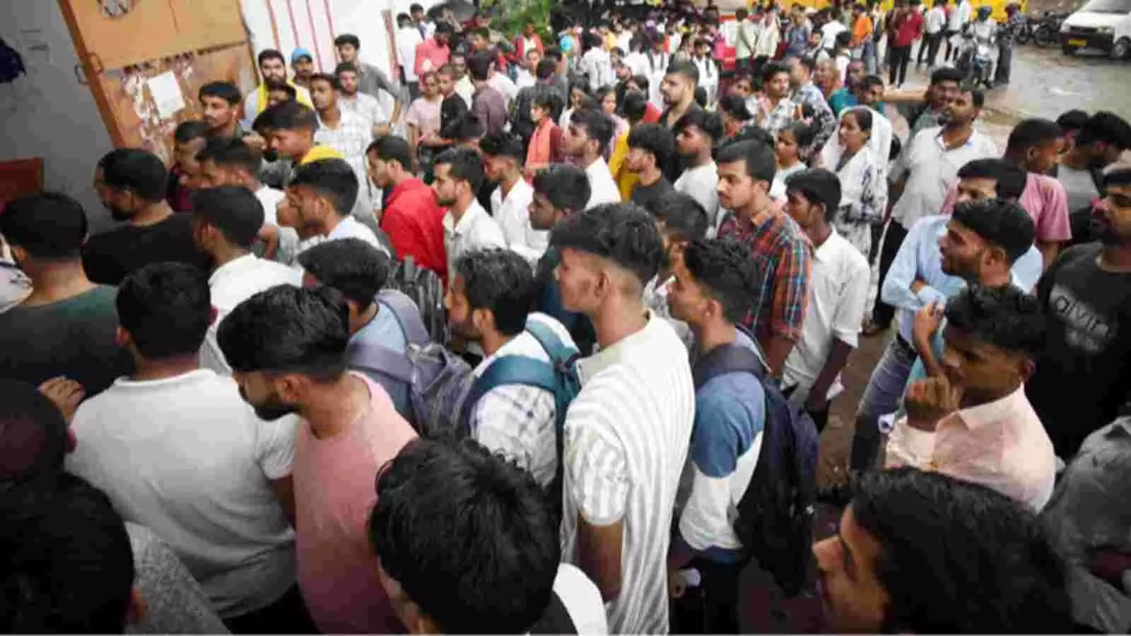 परीक्षा केंद्र के बाहर कतार में खड़े नीट यूजी के अनेक परीक्षार्थी।