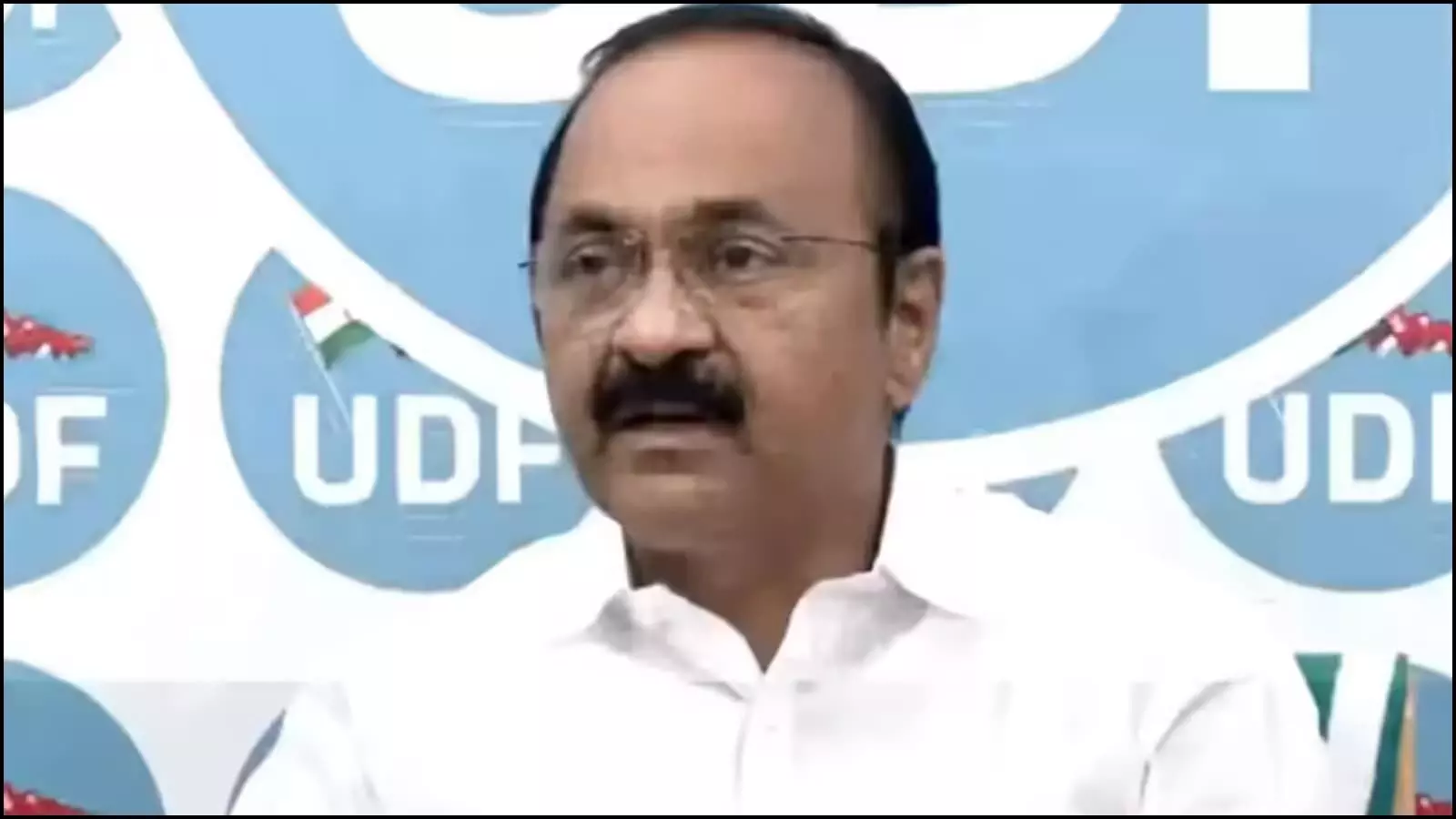 तिरुवनंतपुरम में यूडीएफ के नीले पोस्टर के सामने प्रेस कॉन्फ्रेंस को संबोधित करते सफेद कमीज पहने वीडी सतीशन।