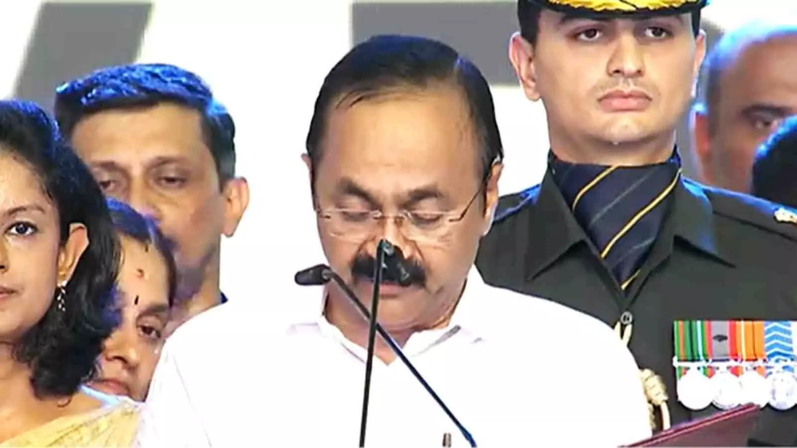 माइक के सामने खड़े होकर दस्तावेज पढ़ते हुए चश्मा लगाए राजनेता वीडी सतीशन माइक के सामने खड़े होकर दस्तावेज पढ़ते हुए चश्मा लगाए राजनेता वीडी सतीशन