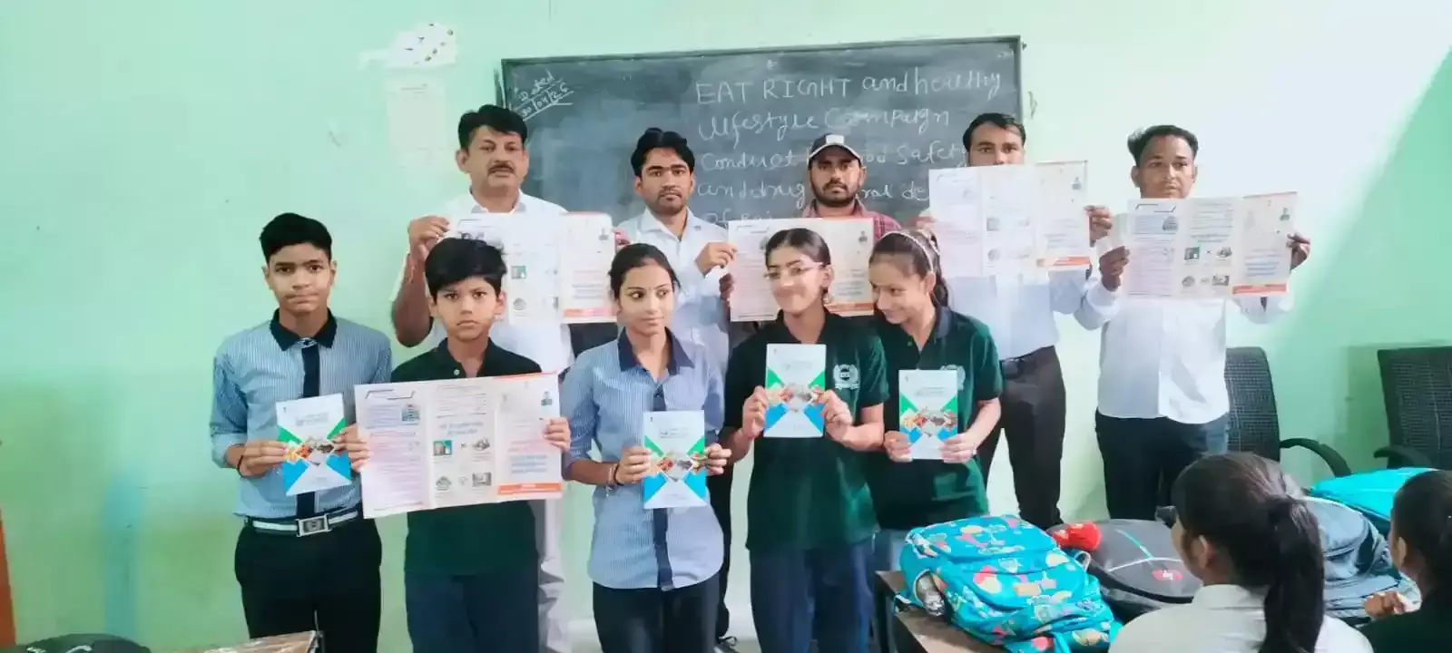 स्कूल के क्लासरूम में खाद्य सुरक्षा अधिकारी विद्यार्थियों को डिब्बाबंद भोजन पर अंकित न्यूट्रिशन लेबल जांचने की विधि सिखा रहे हैं।