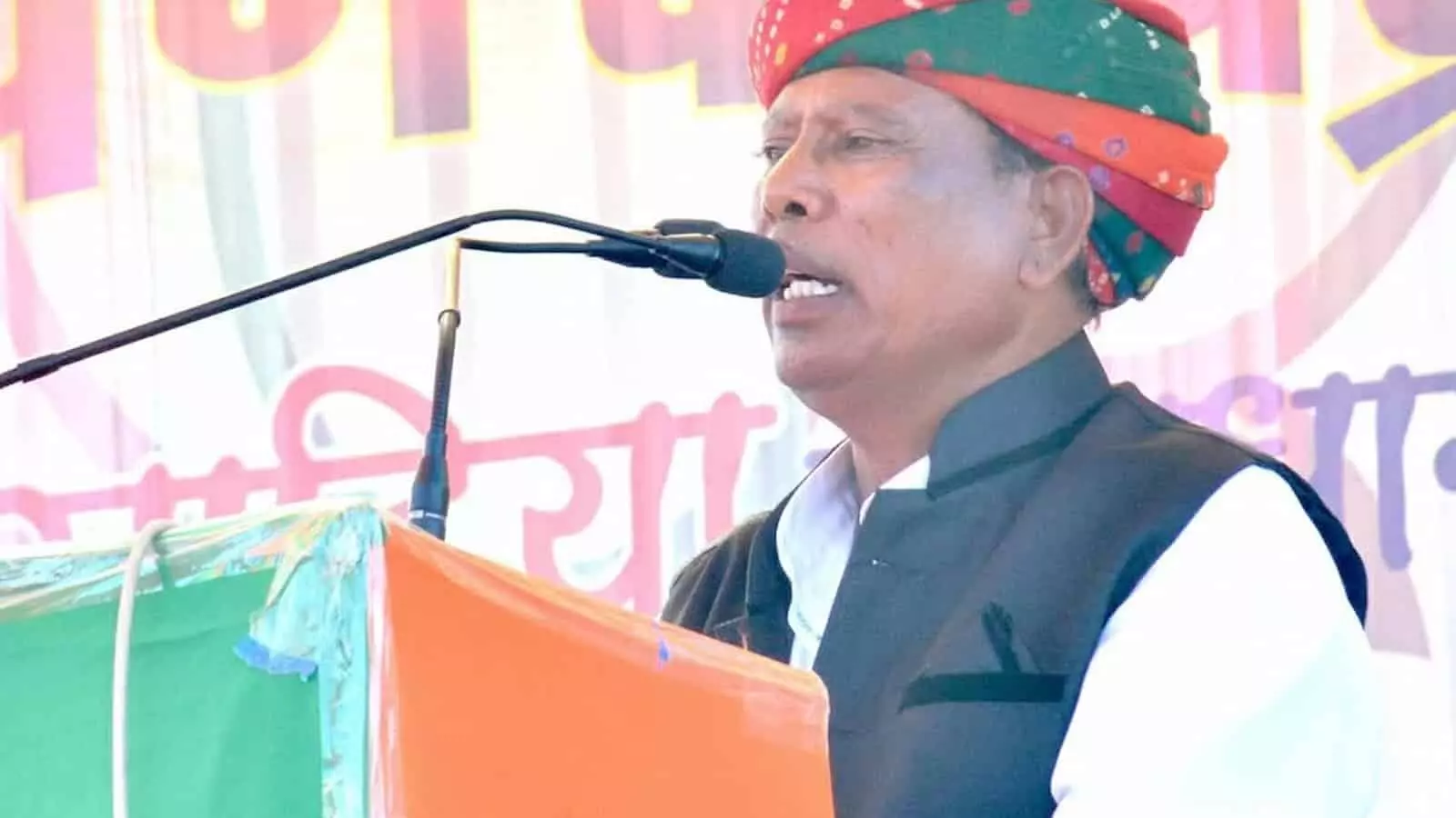 माइक के सामने भाषण देते हुए राजस्थानी साफा पहने पूर्व विधायक गौतमलाल मीणा का चित्र।