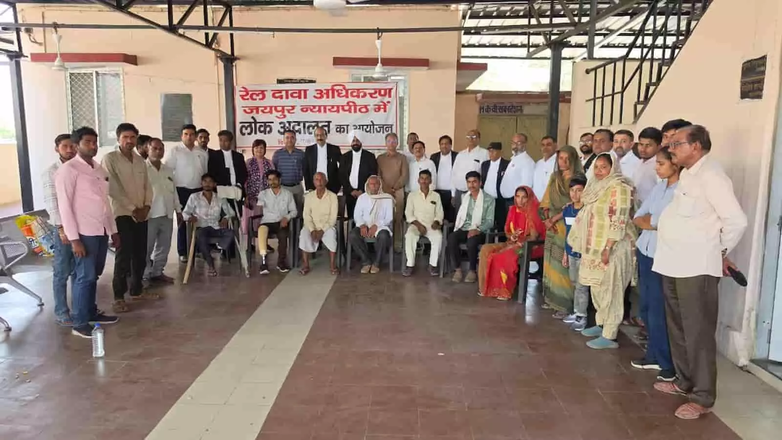 जयपुर रेल दावा अधिकरण परिसर में लोक अदालत के दौरान बैनर के सामने खड़े अधिकारी, अधिवक्ता और पीड़ित लोग। जयपुर रेल दावा अधिकरण परिसर में लोक अदालत के दौरान बैनर के सामने खड़े अधिकारी, अधिवक्ता और पीड़ित लोग।
