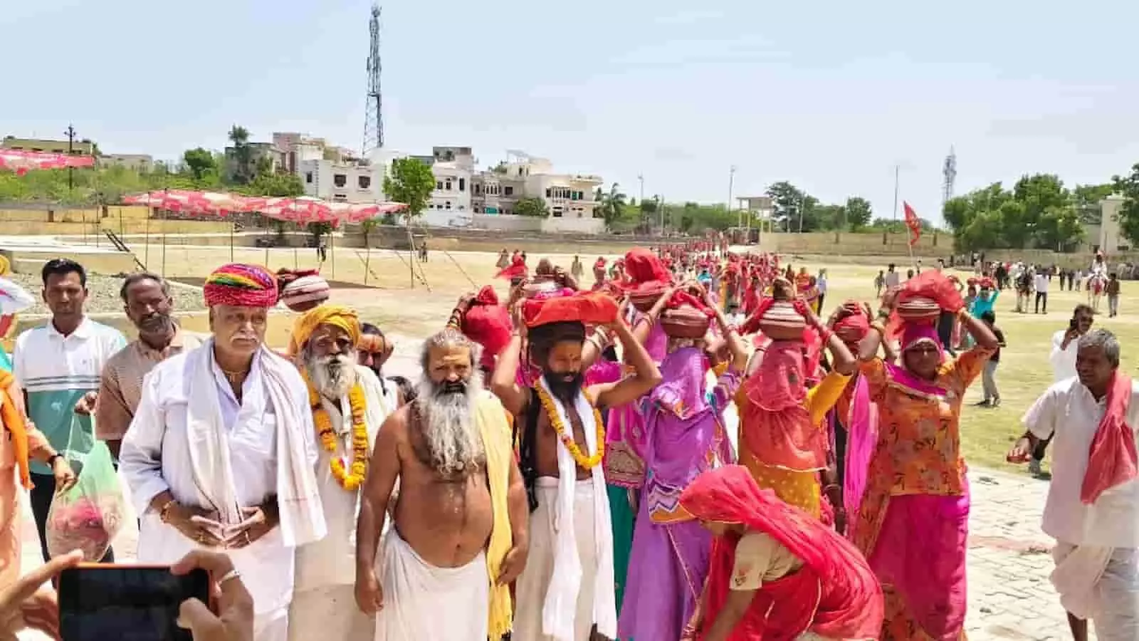कलश यात्रा के दौरान सिर पर कलश रखे महिलाएं और संत समाज हनुमान मंदिर मार्ग पर पैदल चलते हुए। कलश यात्रा के दौरान सिर पर कलश रखे महिलाएं और संत समाज हनुमान मंदिर मार्ग पर पैदल चलते हुए।