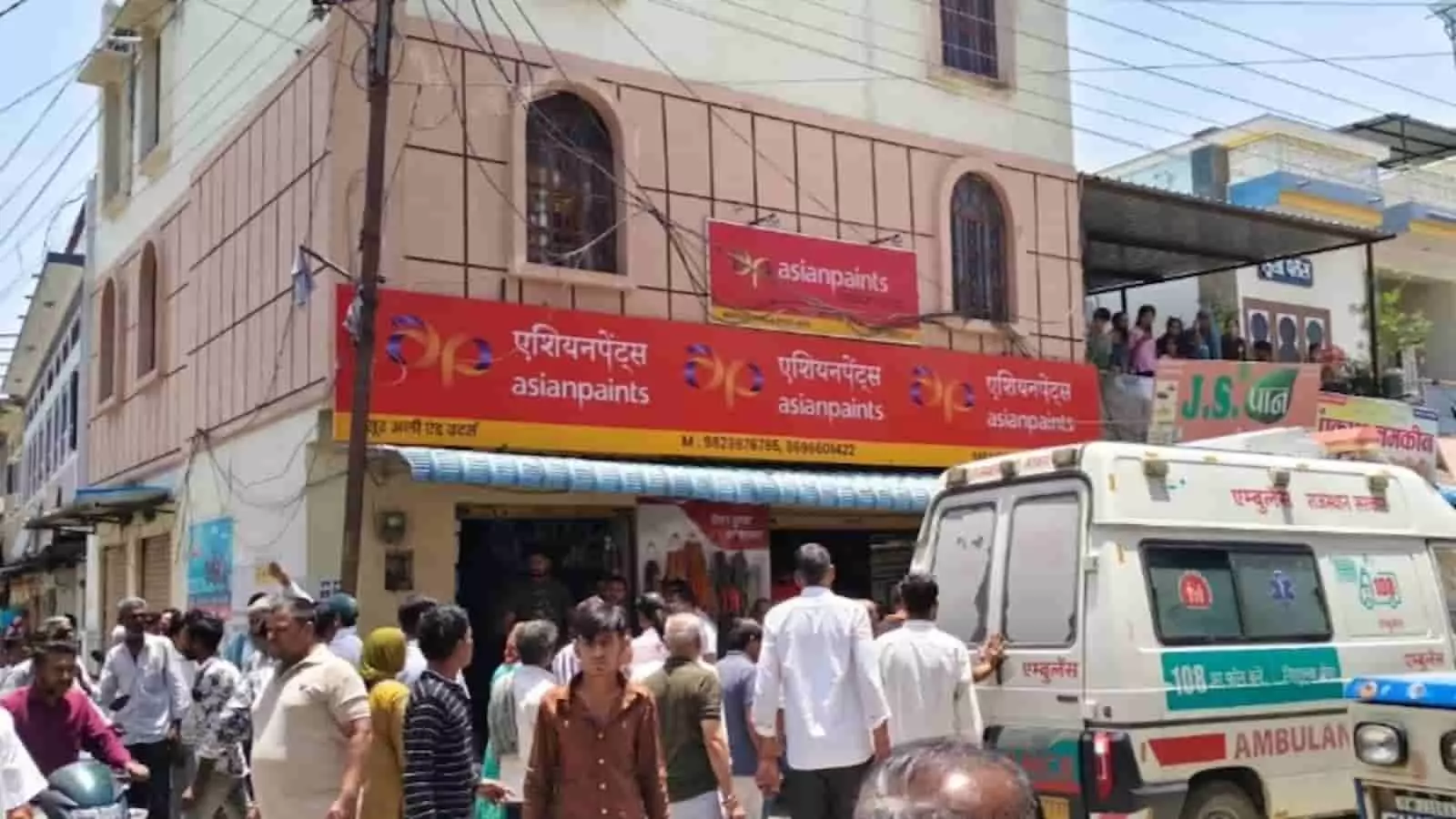 एशियन पेंट्स की दुकान के बाहर खड़ी सफेद एम्बुलेंस और आसपास खड़े लोग। एशियन पेंट्स की दुकान के बाहर खड़ी सफेद एम्बुलेंस और आसपास खड़े लोग।