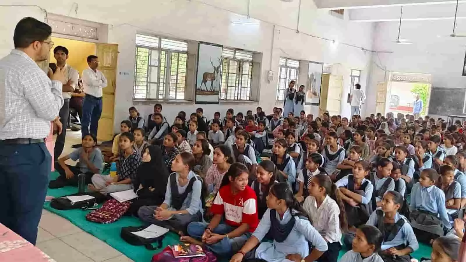 सवाई माधोपुर के विद्यालय सभागार में जमीन पर बैठकर प्रशिक्षण सत्र में भाग लेतीं छात्राएं।