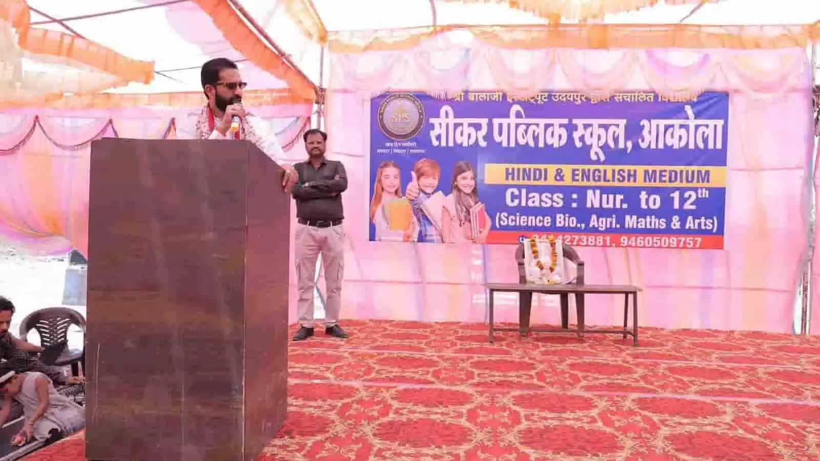 आकोला में स्कूल उद्घाटन समारोह के दौरान मंच पर पोडियम से भाषण देते विधायक अर्जुन लाल जीनगर आकोला में स्कूल उद्घाटन समारोह के दौरान मंच पर पोडियम से भाषण देते विधायक अर्जुन लाल जीनगर