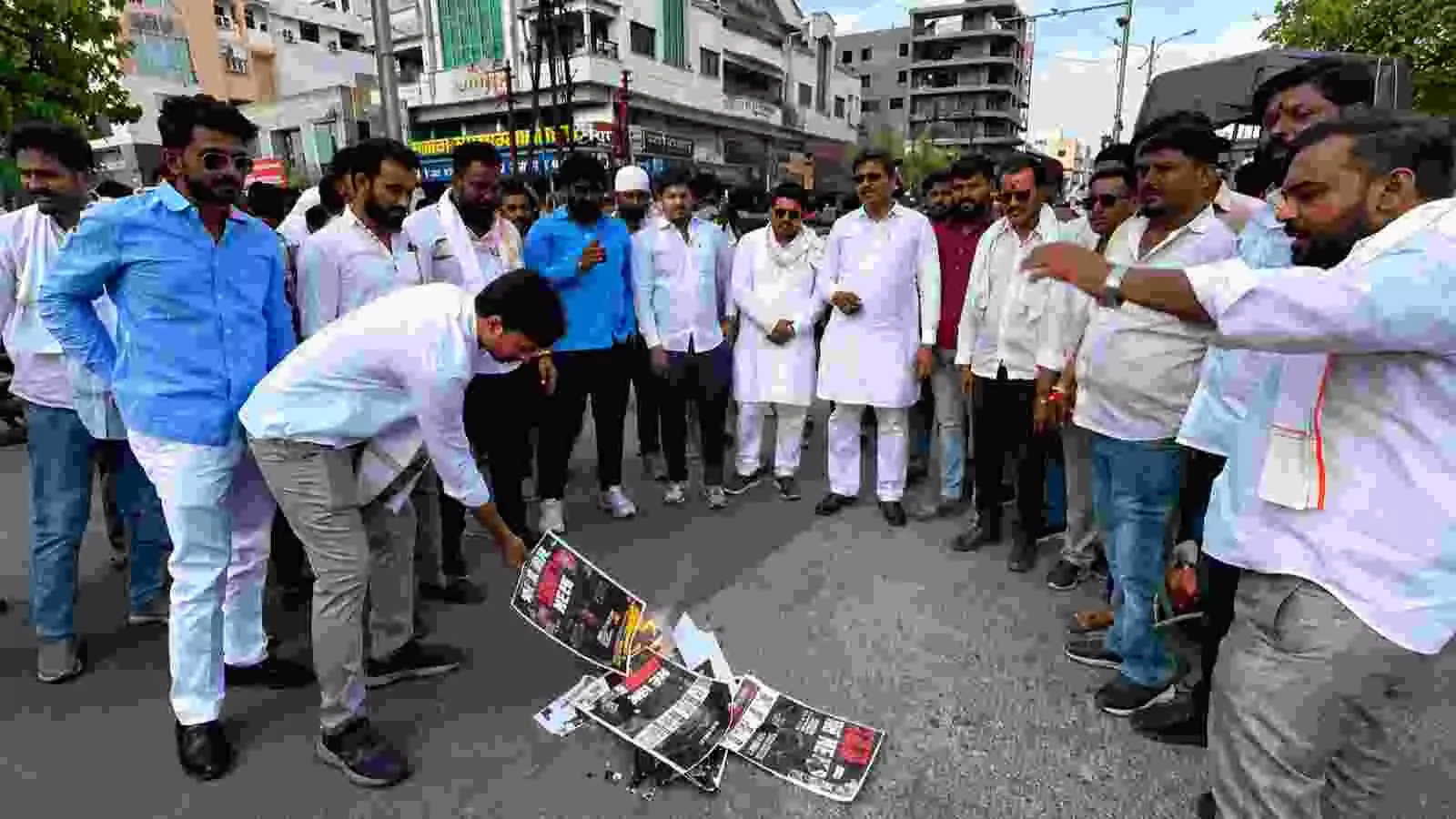 सड़क पर खड़े होकर नारेबाजी करते और पोस्टर लहराते हुए प्रदर्शनकारियों का समूह। सड़क पर खड़े होकर नारेबाजी करते और पोस्टर लहराते हुए प्रदर्शनकारियों का समूह।