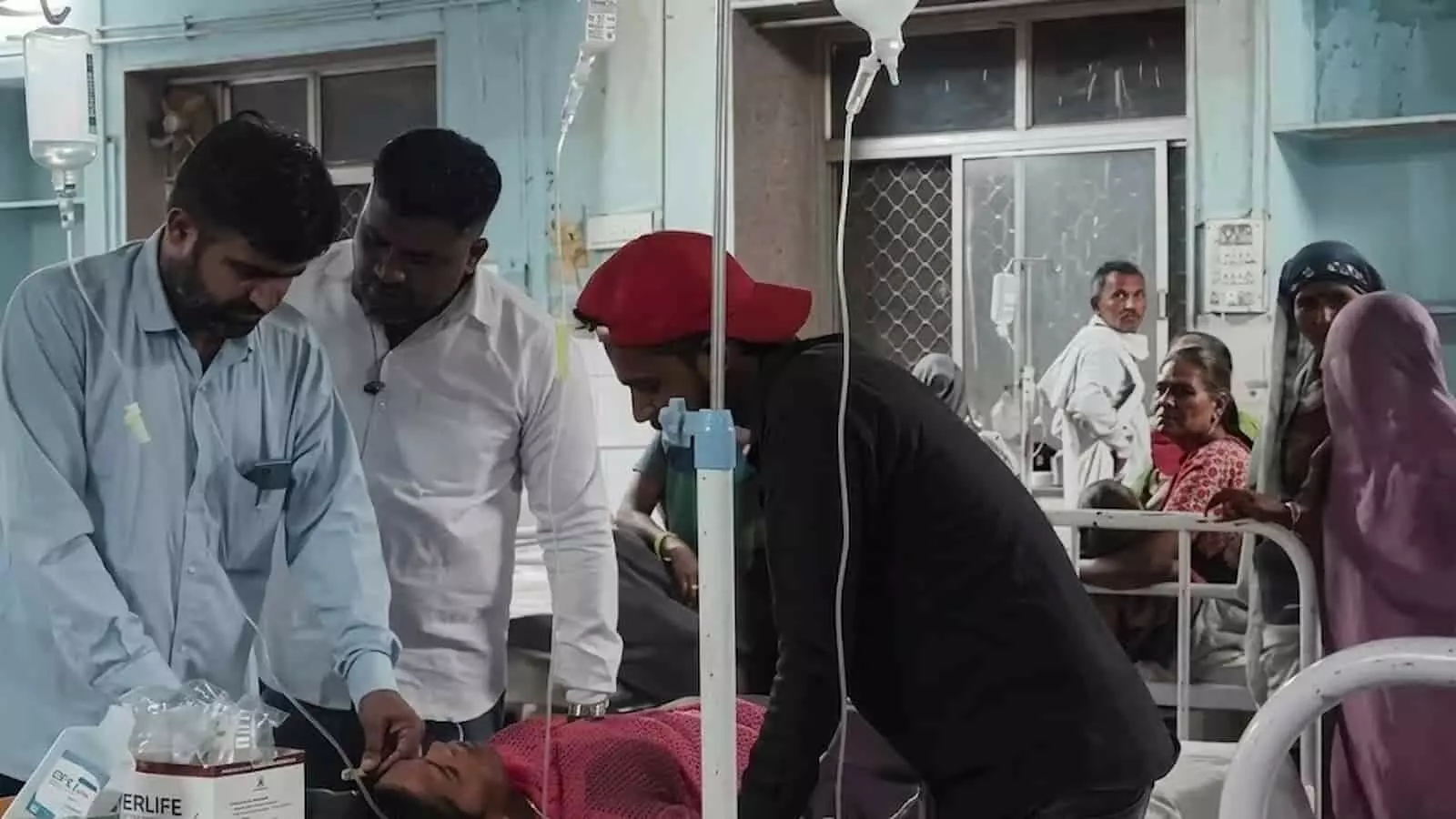 चित्तौड़गढ़ जिला अस्पताल के वार्ड में बेड पर लेटे मरीज का इलाज करते डॉक्टर और खड़े हुए लोग चित्तौड़गढ़ जिला अस्पताल के वार्ड में बेड पर लेटे मरीज का इलाज करते डॉक्टर और खड़े हुए लोग